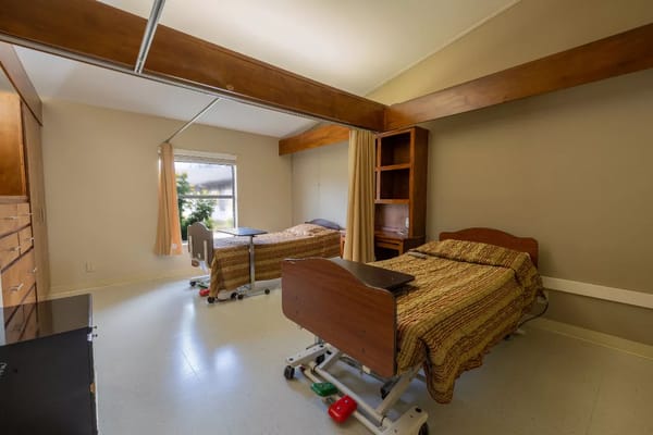 Private resident room with two beds and a window