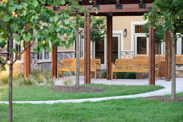 Outdoor seating area with benches and greenery