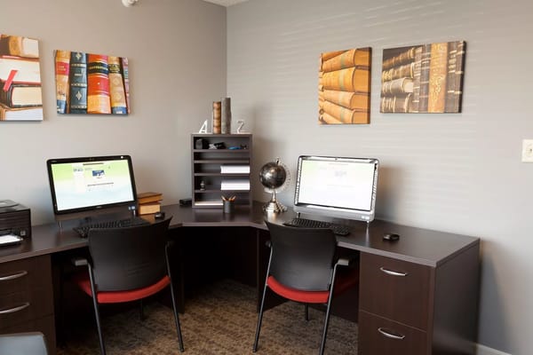 Corner office space with two computers and bookshelves