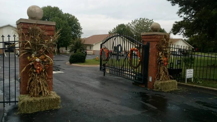 Gated entrance decorated for fall with wreaths and hay