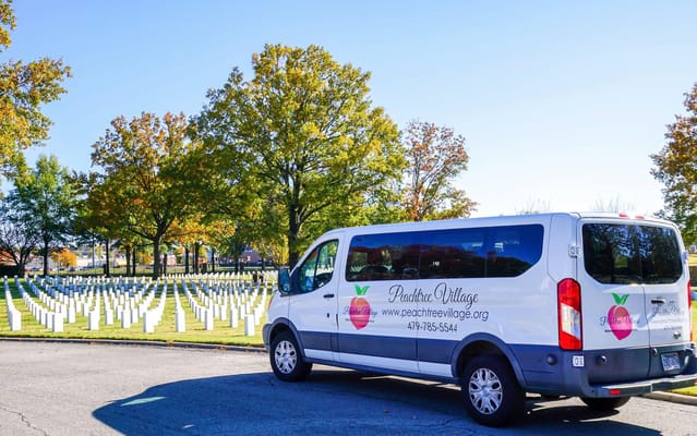 Facility van parked near a memorial display outdoors
