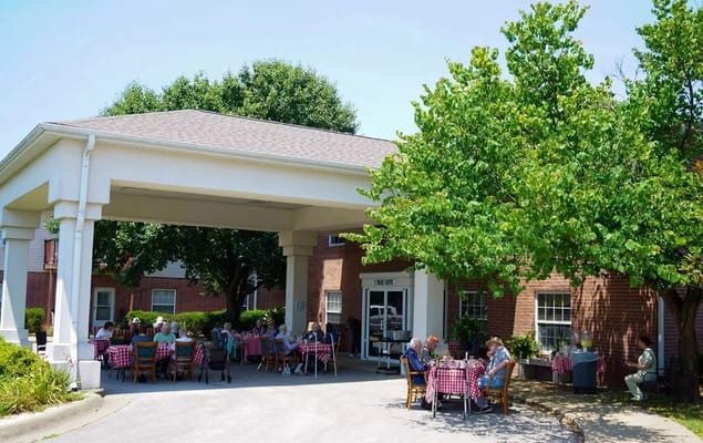 Residents enjoying an outdoor meal under a covered area