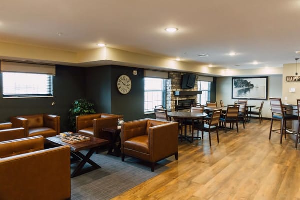 Common area seating with tables in a cozy lounge