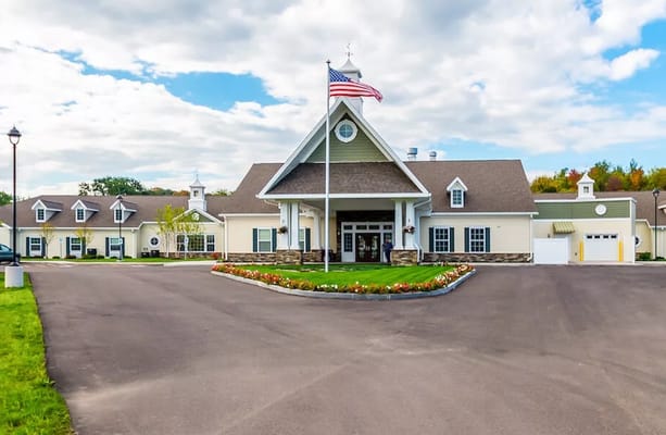 Exterior view of Peregrine Senior Living facility with flag