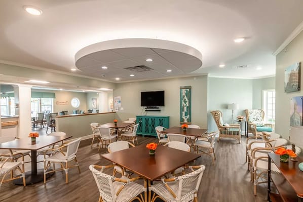Bright common area with tables and chairs for residents