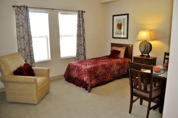 Well-furnished private resident room with bed and chair