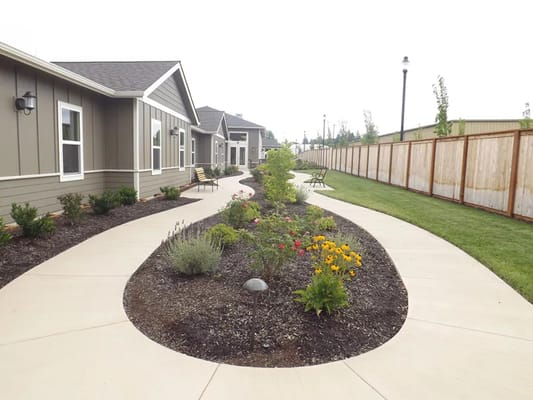 Curved walkway with flower beds in a garden area