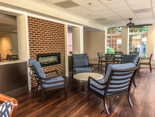 Lounge area with chairs and a fireplace in a retirement community
