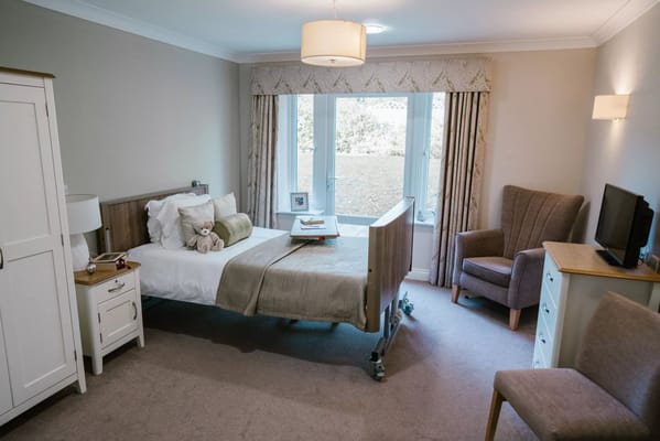 Cozy private resident room with a bed and armchair