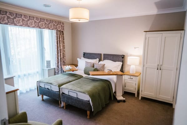 A well-furnished resident room with twin beds