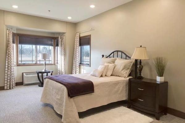 Comfortable bedroom with a bed, nightstand, and window views