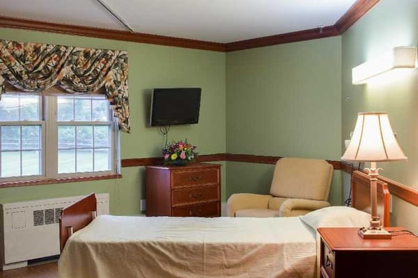 Comfortable bedroom with a bed, dresser, and seating area