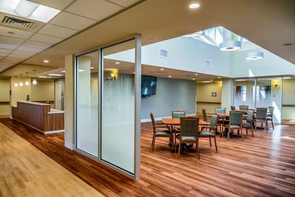 Interior view of a common area with dining tables and a reception desk