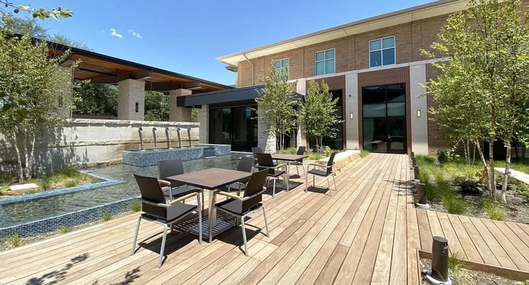 Outdoor seating area with a water feature near the facility