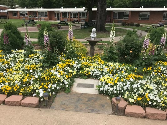 Flower garden featuring a fountain statue at Presbyterian Village