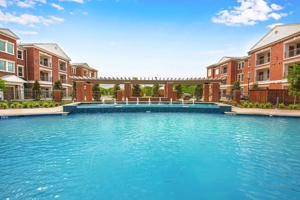 Outdoor swimming pool surrounded by red brick buildings