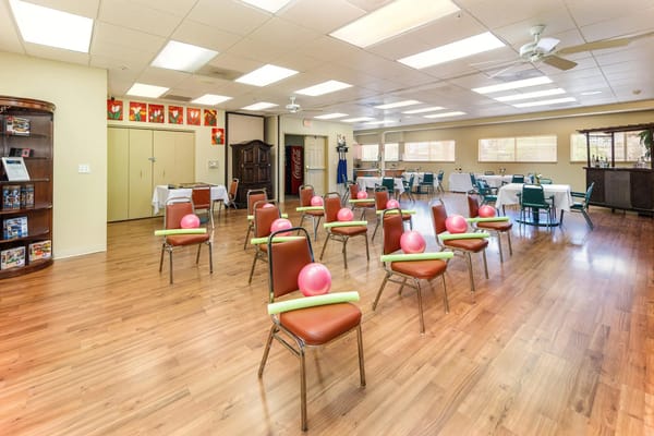 Activity room set up for exercise class with chairs and equipment