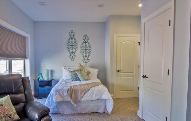 A cozy bedroom with a bed, pillows, and decorative wall art.