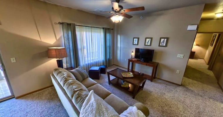 Cozy living room with a couch, lamp, and TV.
