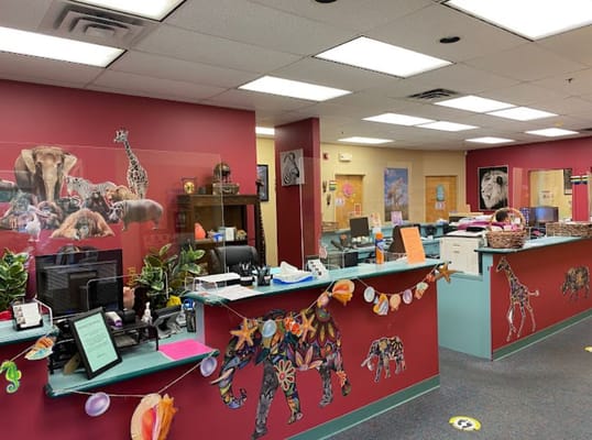 Colorful reception area featuring animal-themed wall art and office desks.
