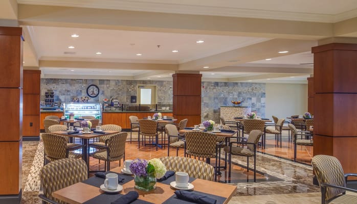Dining area with tables and chairs, well-lit and welcoming