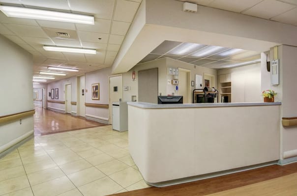 Reception area with a counter and hallways at ProMedica Skilled Nursing and Rehabilitation.