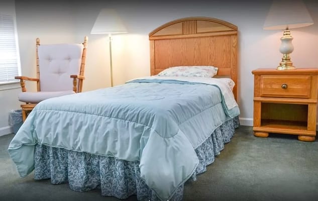 Cozy private resident room with a bed and chair