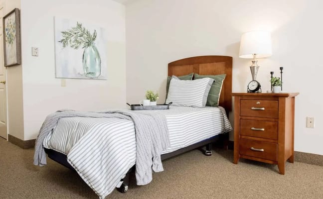 Cozy resident room with bed, nightstand, and artwork