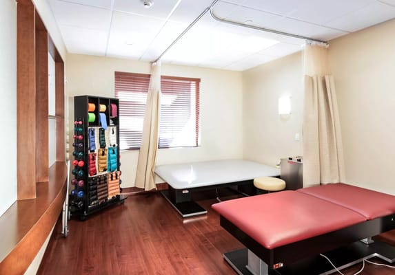 A therapy room featuring exercise equipment and treatment tables.