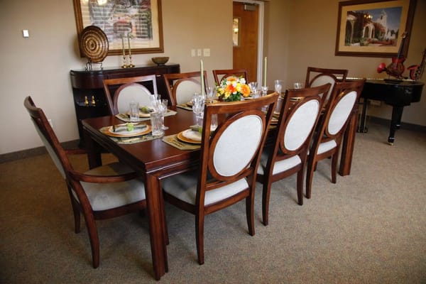 A beautifully set dining table with floral centerpiece in a senior living facility.