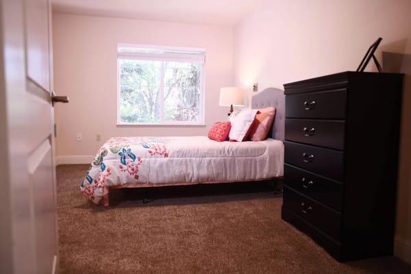 Cozy private resident room with a bed and dresser