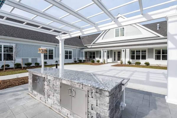 Outdoor patio area with a grill and seating