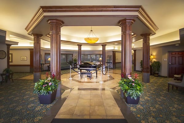Lobby area with a piano and decorative plants
