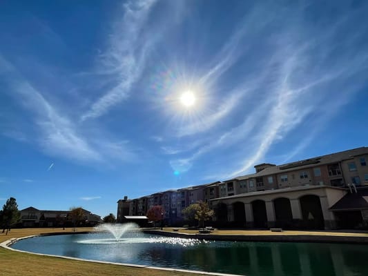 Sun shining over the lake with a fountain at Raider Ranch