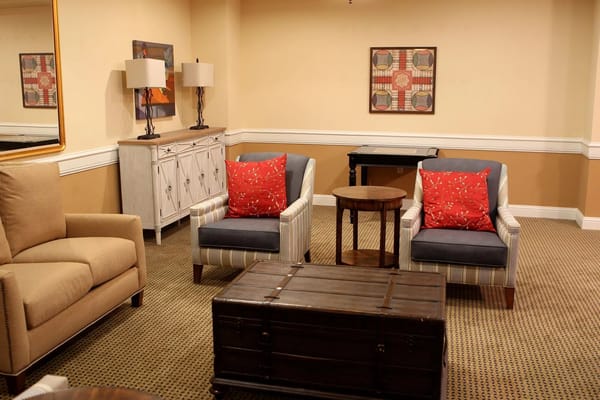 Cozy seating area with two chairs, a coffee table, and decorative lamps.