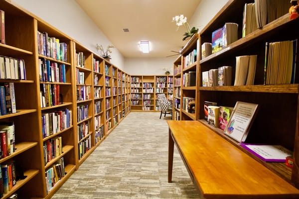 Bookshelves lined with books in the library of Raider Ranch.