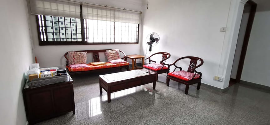 Living room with traditional wooden seating and a fan