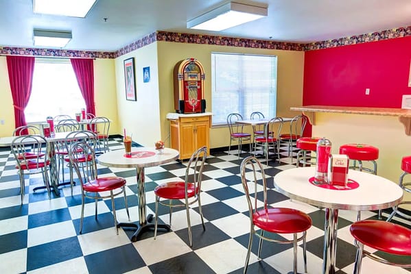 Bright cafeteria with red and black seating and jukebox