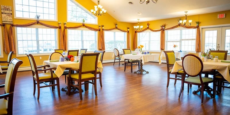Brightly lit dining room with tables and chairs