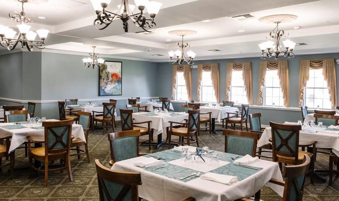 Elegant dining room with tables and chairs set in preparation for a meal.