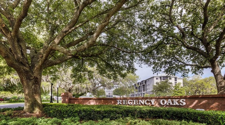Sign reading 'Regency Oaks' surrounded by trees