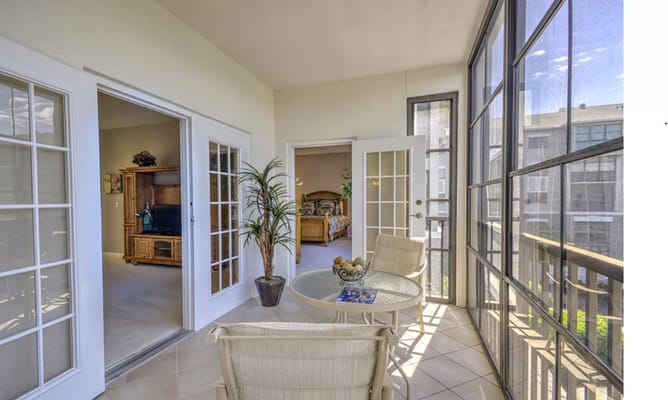Sunroom with a table and chairs, looking into a living space.