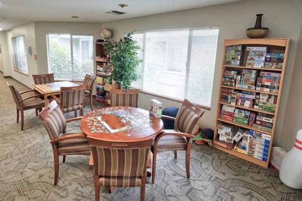 Common area with tables and a bookshelf filled with games
