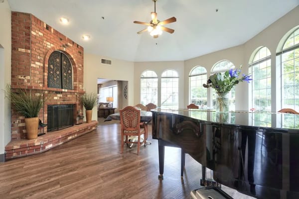 Bright common area with a piano and large windows