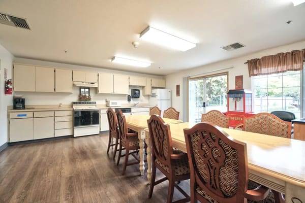 Bright dining area with a large table and kitchen appliances