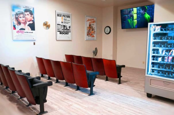 Seating area in the theater room with posters on the wall.