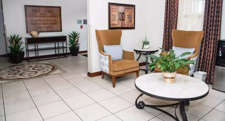 Lobby area with armchairs, decorative table, and plants