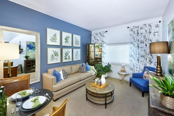 Stylish living room featuring a sofa, dining table, and decorative artwork.