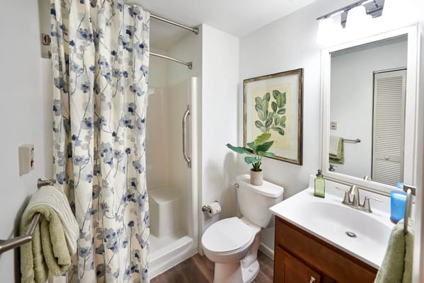 View of a modern bathroom with shower, toilet, and sink