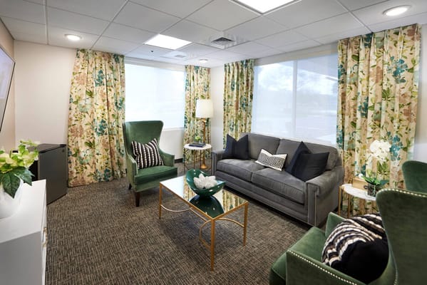 Comfortable living room with a green armchair, gray sofa, and decorative plants